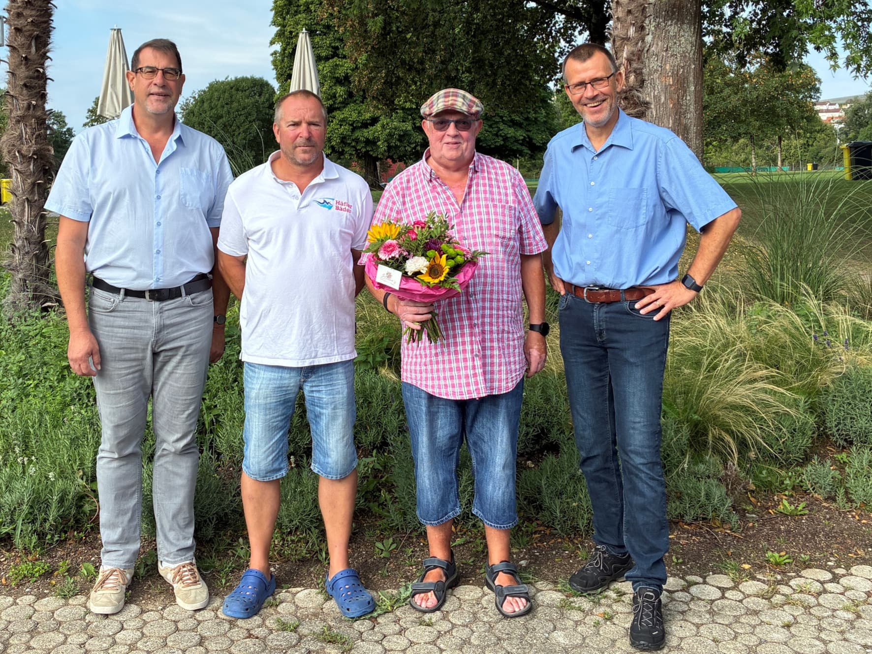 (von links) Ortvorsteher Andreas Lipp, Betriebsleiter Andreas Fehrmann und Detlev Maaß, Leiter des Amtes für Sport, Freizeit und außerschulische Bildung begrüßten John Rädler (Zweiter von rechts) mit Blumen und einem Gutschein.