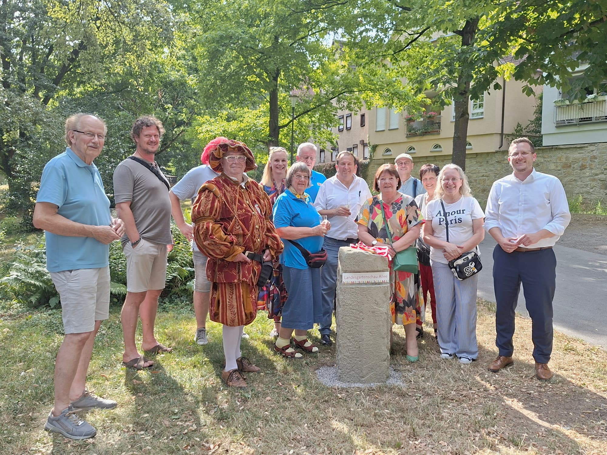 Oberbürgermeister Patrick Wegener und Gäste am neuen Gedenkstein der Landesgartenschau-Allee im Öhringer Hofgarten