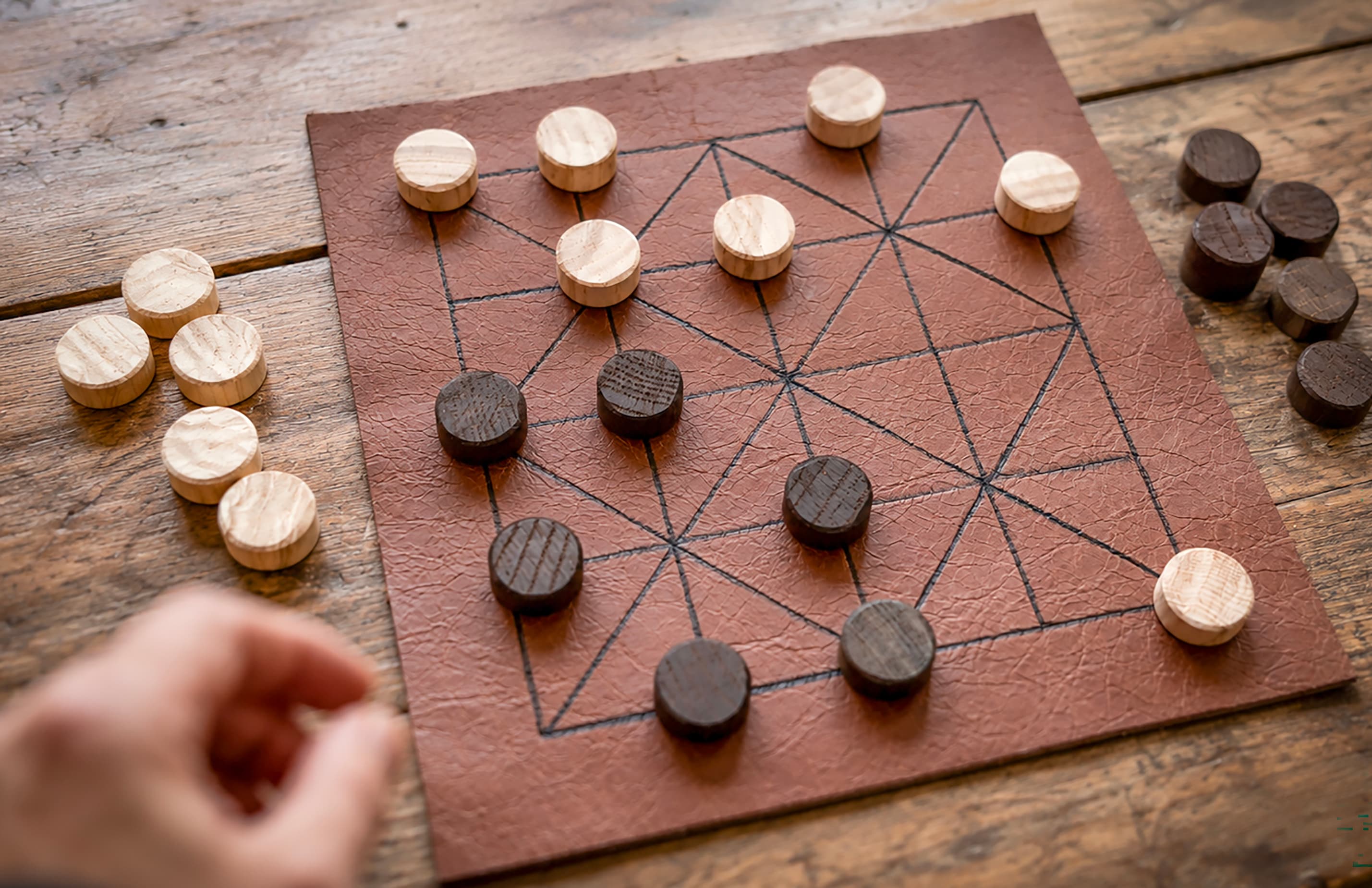 Historisches Brettspiel Alquerque mit hellen und dunklen Spielsteinen